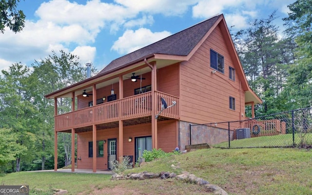 rear view of house with a balcony, a lawn, and ceiling fan