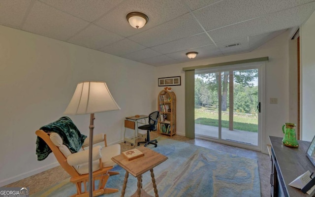 living area with a drop ceiling