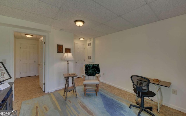 carpeted office space with a paneled ceiling