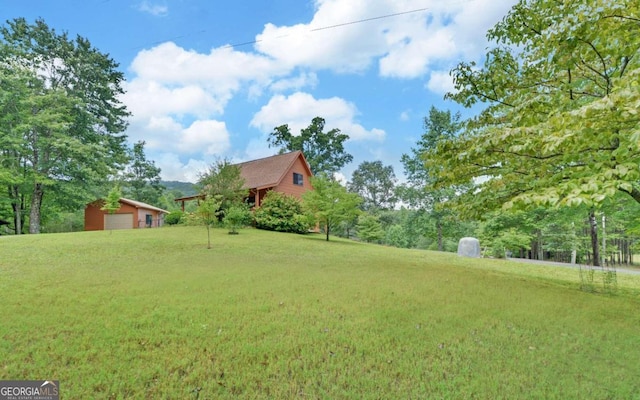 view of yard featuring a garage and an outbuilding