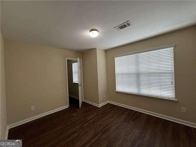 spare room featuring a wealth of natural light and hardwood / wood-style floors