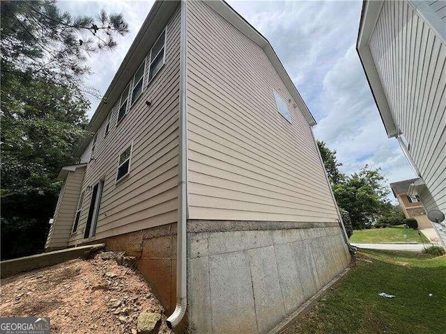 view of side of home with a yard