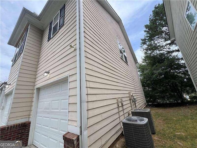 view of side of property with a garage and central AC unit