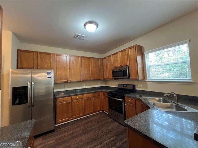 kitchen with sink, appliances with stainless steel finishes, and dark hardwood / wood-style flooring