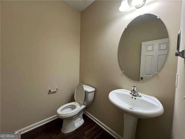 bathroom featuring hardwood / wood-style flooring and toilet