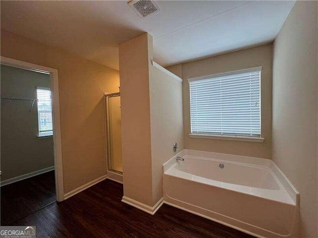 bathroom with hardwood / wood-style flooring and separate shower and tub