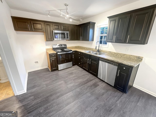 kitchen featuring sink, dark wood-type flooring, stainless steel appliances, and light stone countertops