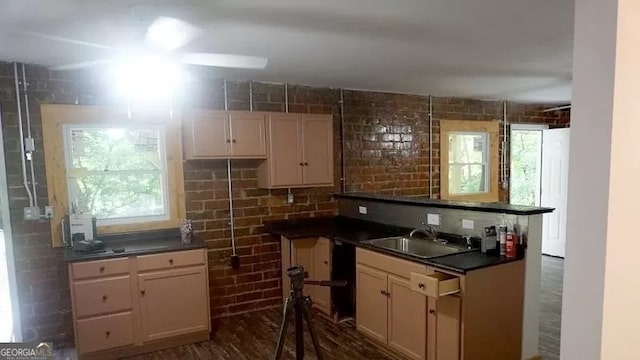 kitchen with dark hardwood / wood-style flooring, kitchen peninsula, sink, and ceiling fan