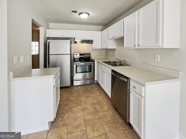 kitchen featuring light tile patterned flooring, sink, white cabinets, stainless steel appliances, and a textured ceiling