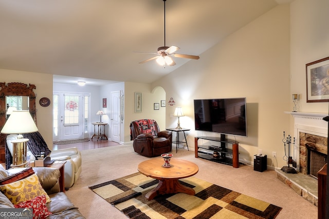 living room with ceiling fan, a stone fireplace, carpet floors, and high vaulted ceiling