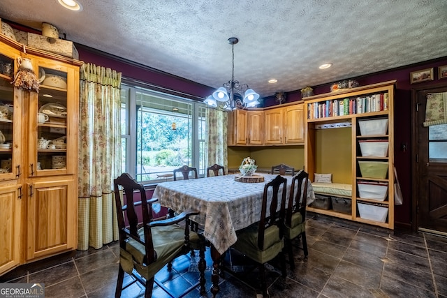 tiled dining room with a textured ceiling and a notable chandelier