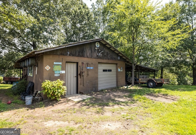 view of outdoor structure with a carport and a yard