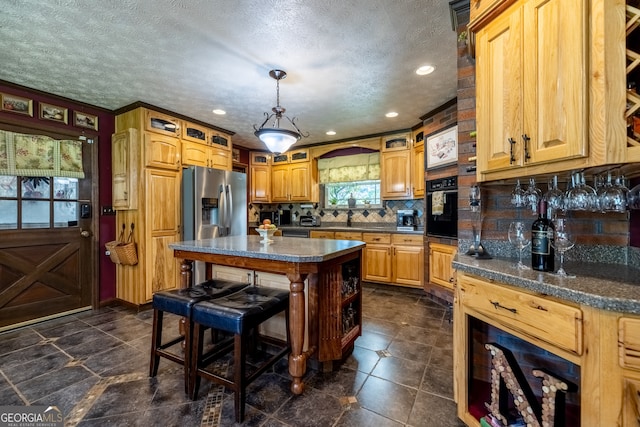 kitchen with stainless steel fridge with ice dispenser, dark tile patterned floors, tasteful backsplash, black oven, and a kitchen island