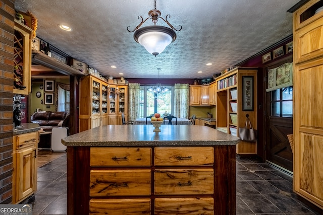 kitchen with brick wall, a center island, and dark tile patterned floors