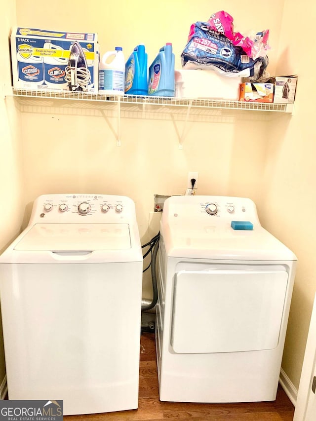 laundry area with separate washer and dryer and hardwood / wood-style floors