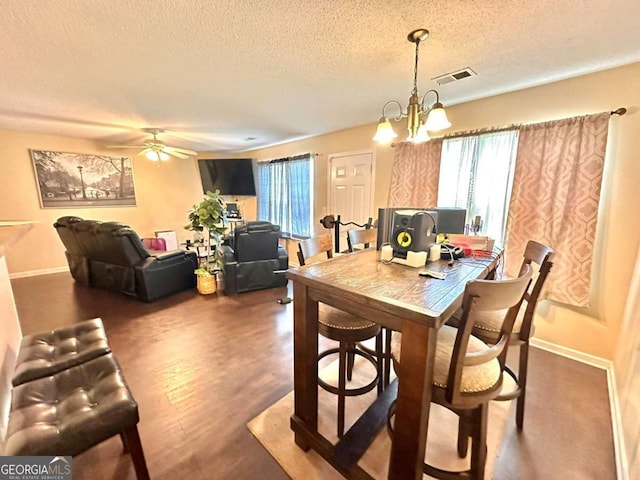 dining area featuring a textured ceiling, wood-type flooring, and plenty of natural light