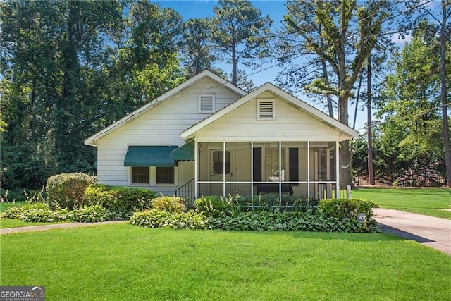 bungalow-style home with a sunroom and a front yard