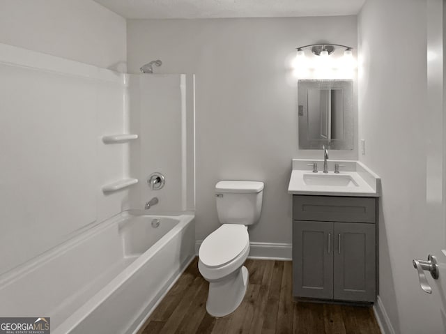 full bathroom featuring vanity, hardwood / wood-style flooring, toilet, and washtub / shower combination