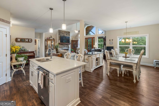 kitchen featuring a center island with sink, dark hardwood / wood-style flooring, stainless steel dishwasher, hanging light fixtures, and sink