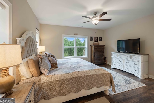 bedroom with dark hardwood / wood-style flooring and ceiling fan