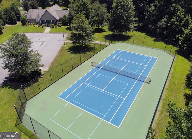 view of tennis court featuring a yard