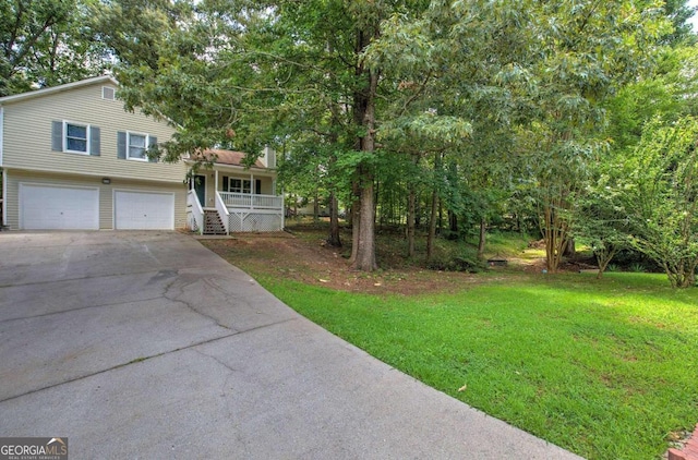 view of front of house with a front yard, covered porch, and a garage