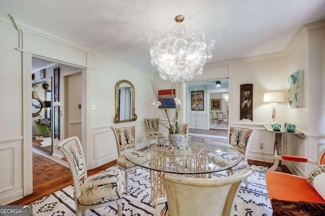 dining room featuring crown molding, hardwood / wood-style floors, and an inviting chandelier