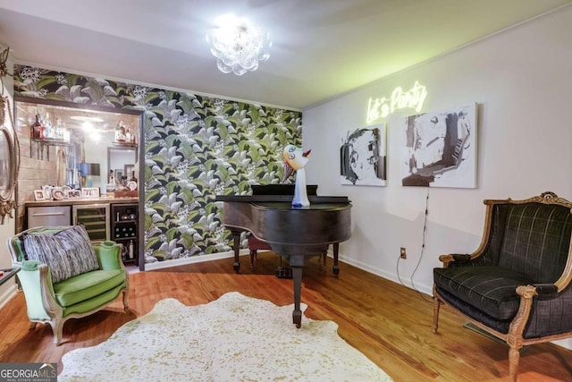 living area with indoor bar, ornamental molding, and hardwood / wood-style floors