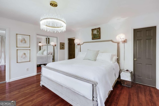 bedroom with dark wood-type flooring, a chandelier, and a closet