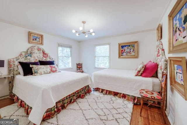 bedroom with an inviting chandelier, hardwood / wood-style floors, and ornamental molding