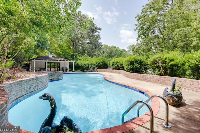 view of swimming pool featuring an outdoor structure and a patio area