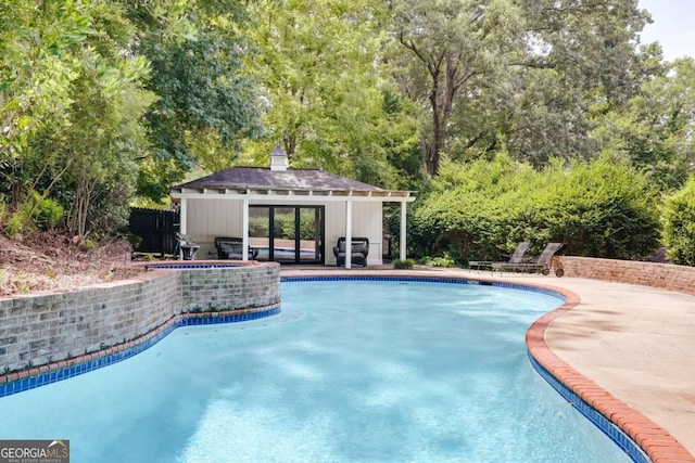 view of swimming pool with a grill, an outdoor structure, and a patio area