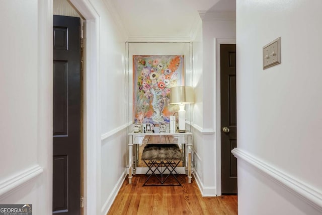 hallway featuring ornamental molding and light hardwood / wood-style flooring