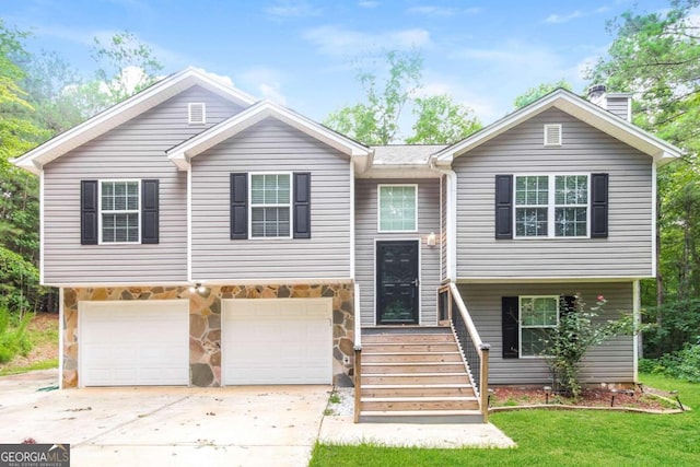 bi-level home featuring a garage and a front yard