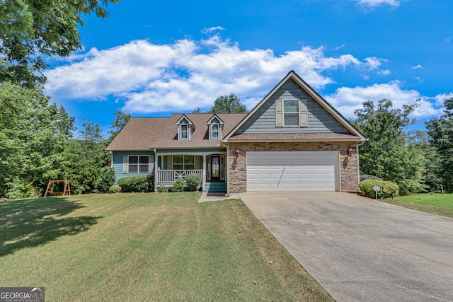 view of front of home featuring covered porch, a garage, and a front yard