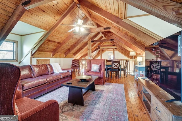 living room with light hardwood / wood-style flooring, a healthy amount of sunlight, and lofted ceiling with beams