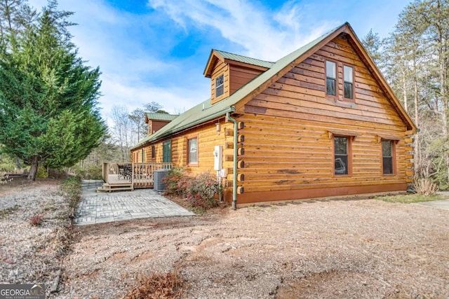 view of property exterior featuring central air condition unit and a wooden deck