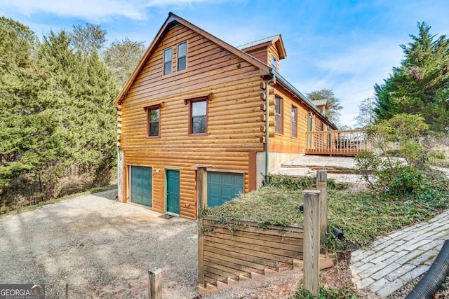 view of side of property with a garage and a wooden deck