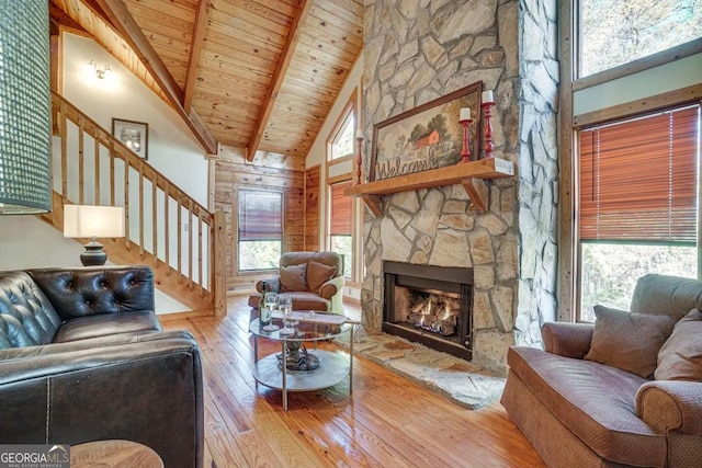 living room with wood ceiling, high vaulted ceiling, hardwood / wood-style flooring, and a fireplace