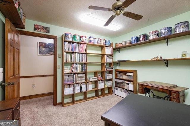 office with a textured ceiling, light colored carpet, and ceiling fan