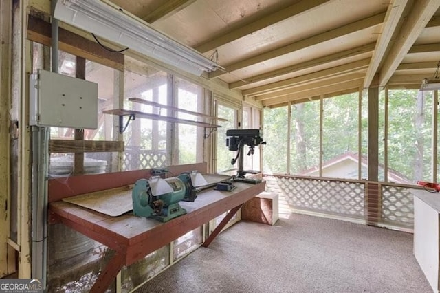 sunroom / solarium featuring beam ceiling and a healthy amount of sunlight