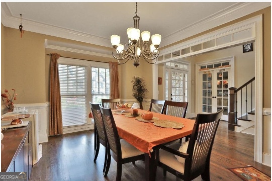 dining area featuring crown molding, dark hardwood / wood-style flooring, a chandelier, and french doors