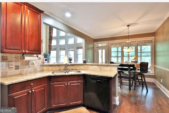 kitchen featuring hardwood / wood-style flooring, sink, dishwasher, light stone countertops, and kitchen peninsula