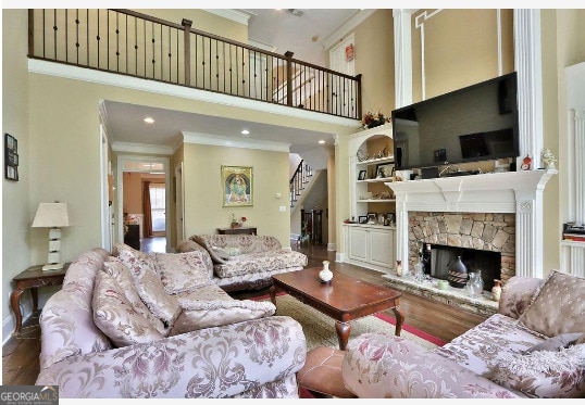 living room featuring a fireplace, crown molding, and hardwood / wood-style floors