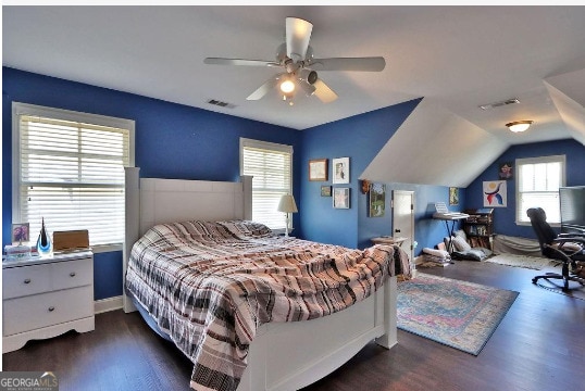 bedroom with vaulted ceiling, dark hardwood / wood-style flooring, multiple windows, and ceiling fan