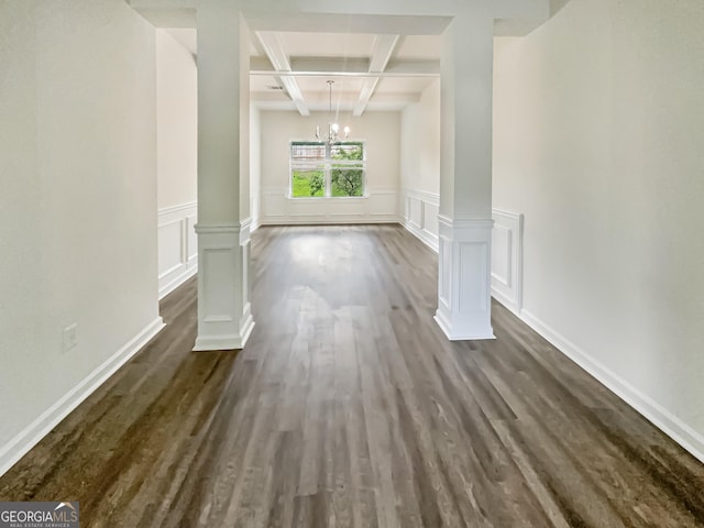 interior space featuring coffered ceiling, an inviting chandelier, dark hardwood / wood-style floors, beamed ceiling, and decorative columns