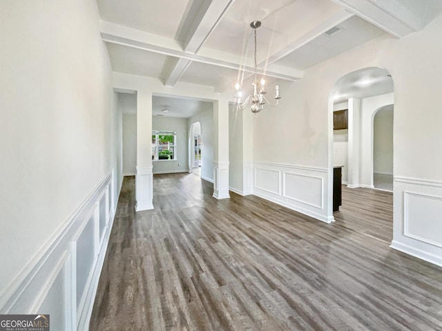 unfurnished dining area with beamed ceiling, dark wood-type flooring, and ornate columns