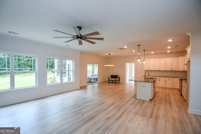 kitchen featuring light hardwood / wood-style flooring, a kitchen island with sink, ceiling fan, hanging light fixtures, and sink