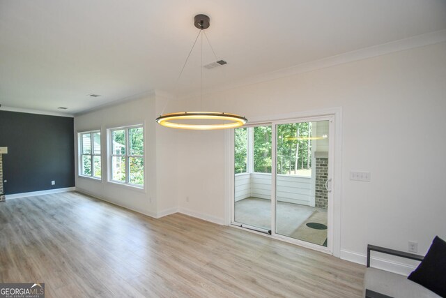 interior space with light wood-type flooring and ornamental molding