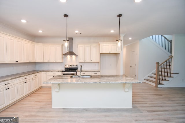 kitchen featuring sink, stainless steel electric range, hanging light fixtures, an island with sink, and wall chimney exhaust hood